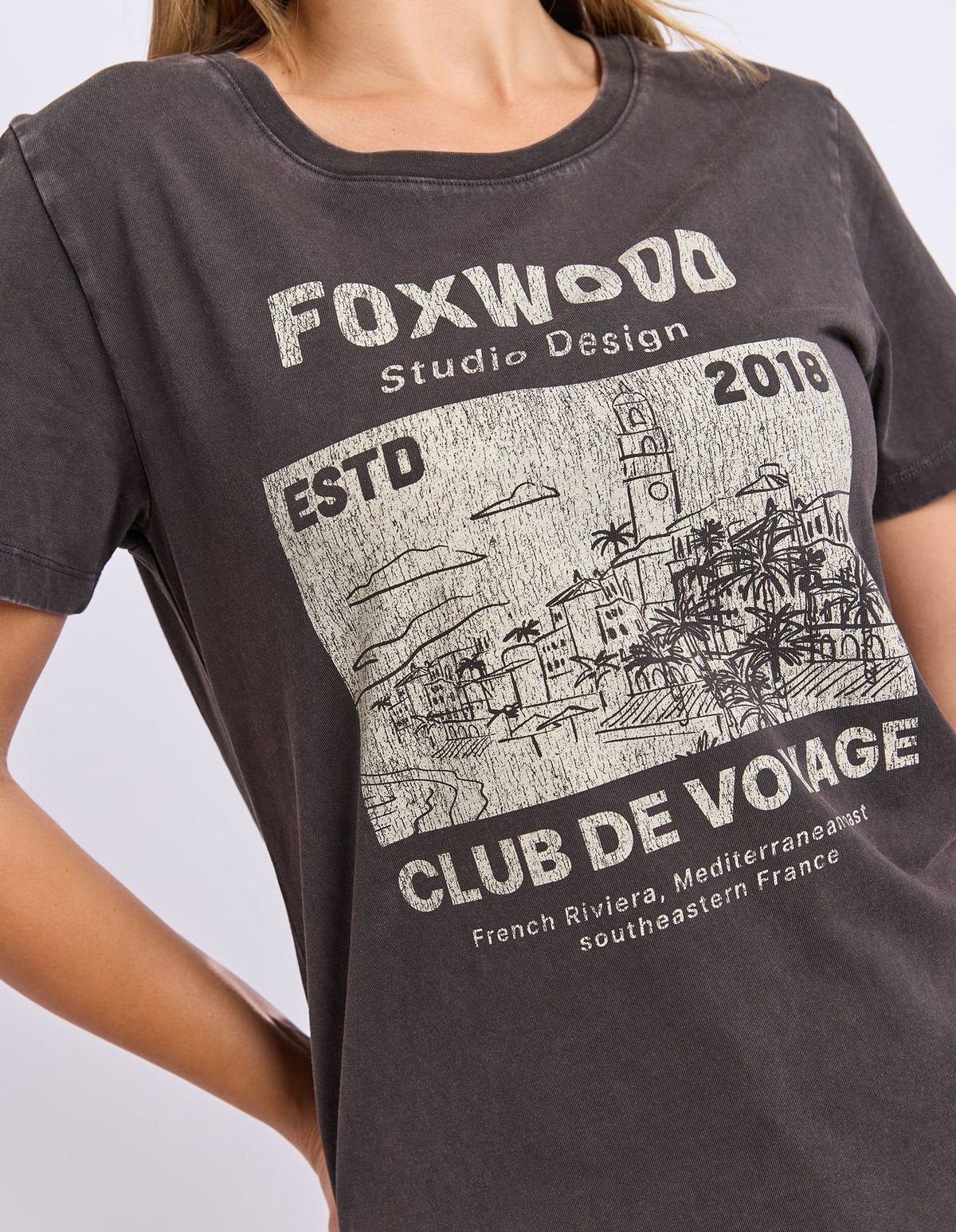 Woman wearing a Foxwood black printed graphic t shirt paired with denim jeans on a plain background