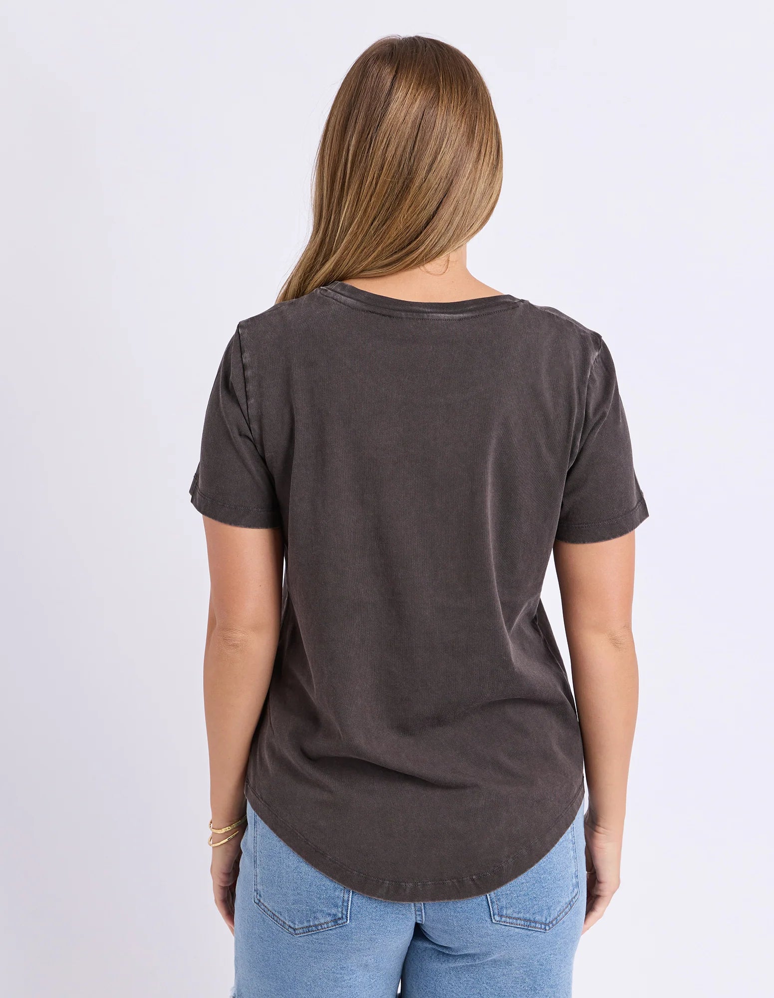 Image of Woman wearing a Foxwood black printed graphic t shirt paired with denim jeans on a plain background