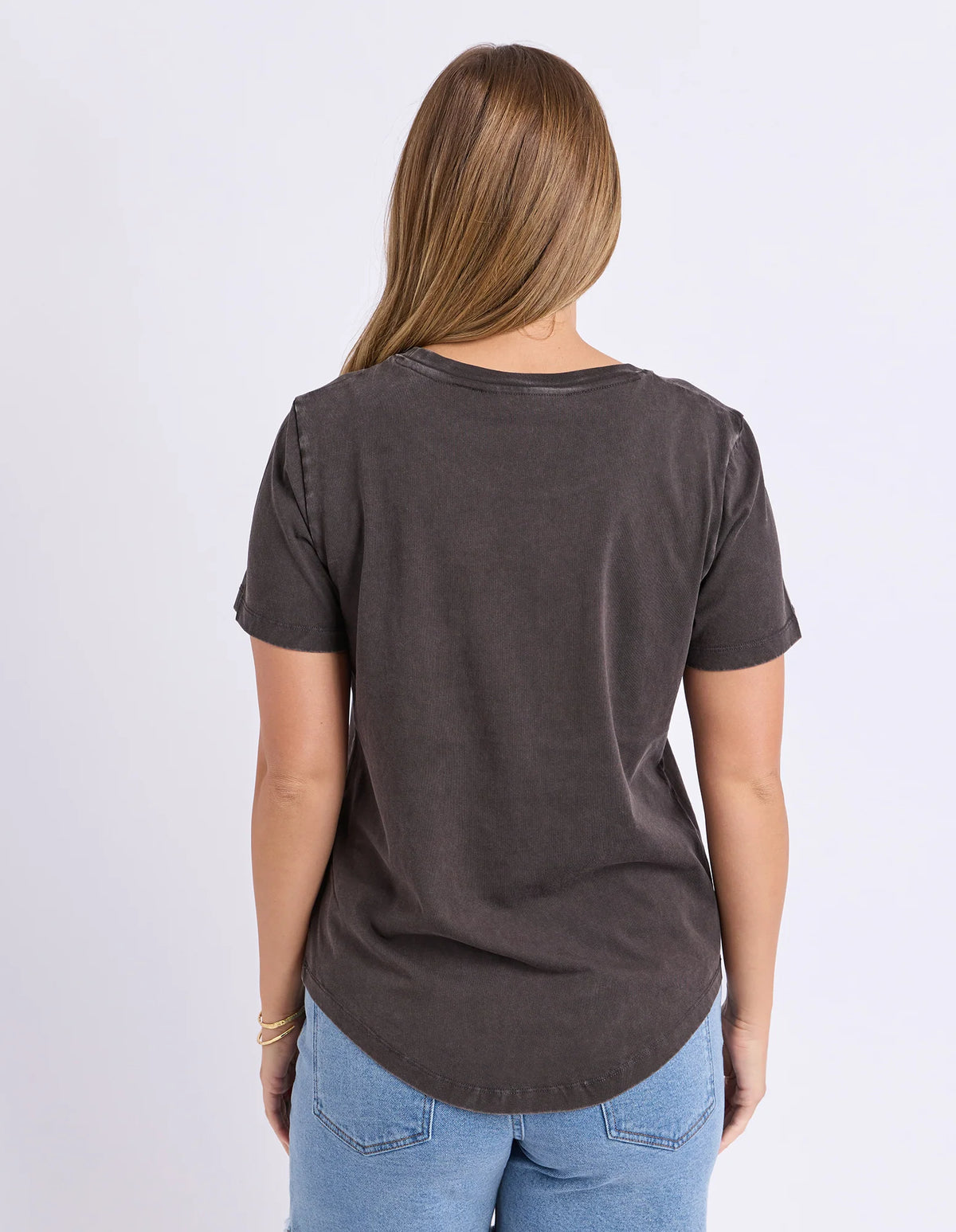 Woman wearing a Foxwood black printed graphic t shirt paired with denim jeans on a plain background