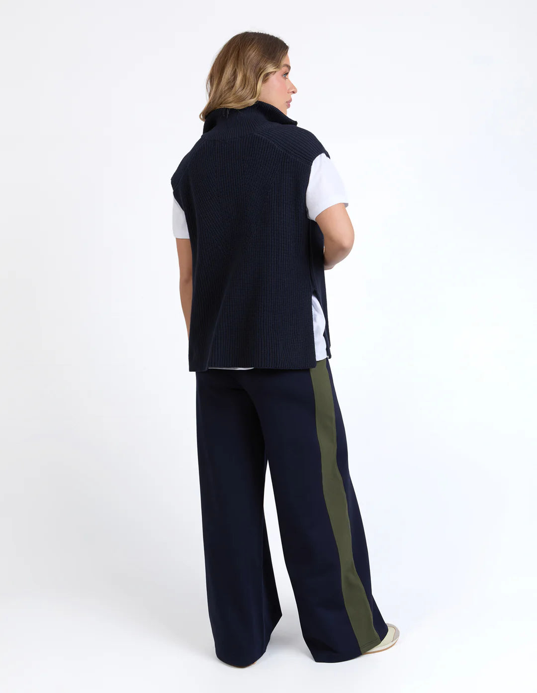 Image of Woman wearing a Foxwood navy vest and pants with a white shirt on a white background