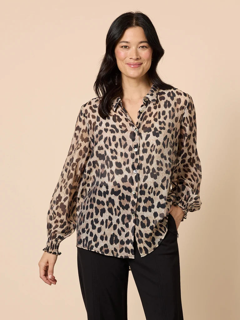Image of Woman wearing a Gordon Smith leopard print blouse against a beige background