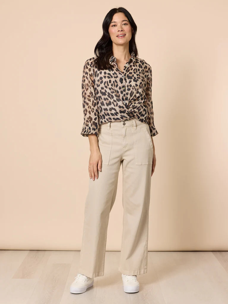 Image of Woman wearing a Gordon Smith leopard print shirt and beige pants against a beige background