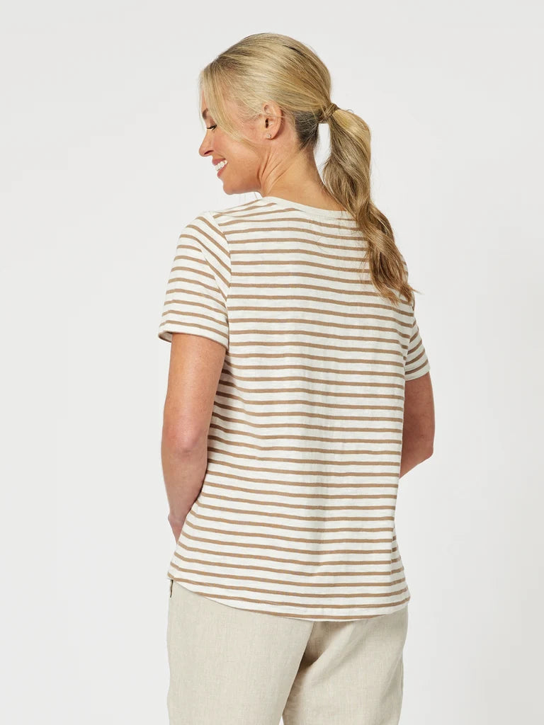 Image of A woman shown from the back wearing a Gordon Smith short-sleeve crewneck t-shirt with thin horizontal beige and white stripes, paired with light beige trousers, against a plain light gray studio background.