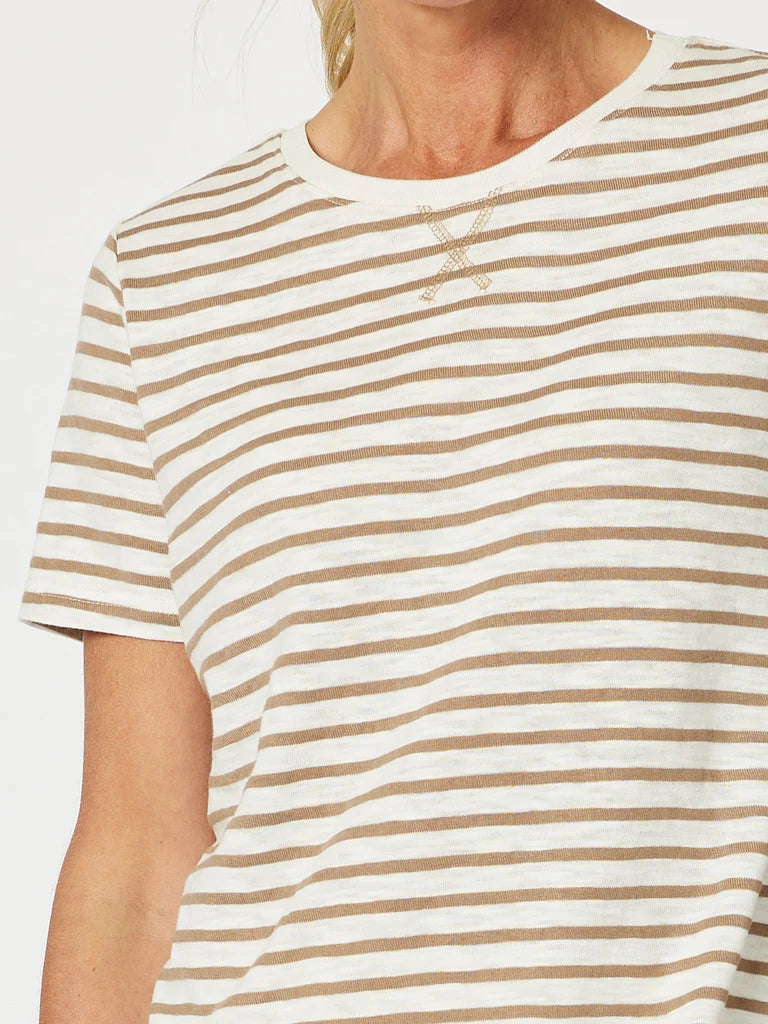 A close-up of a woman wearing a Gordon Smith short-sleeve crew-neck T-shirt with horizontal beige and off-white stripes and a small crossed-strap detail at the center chest.
