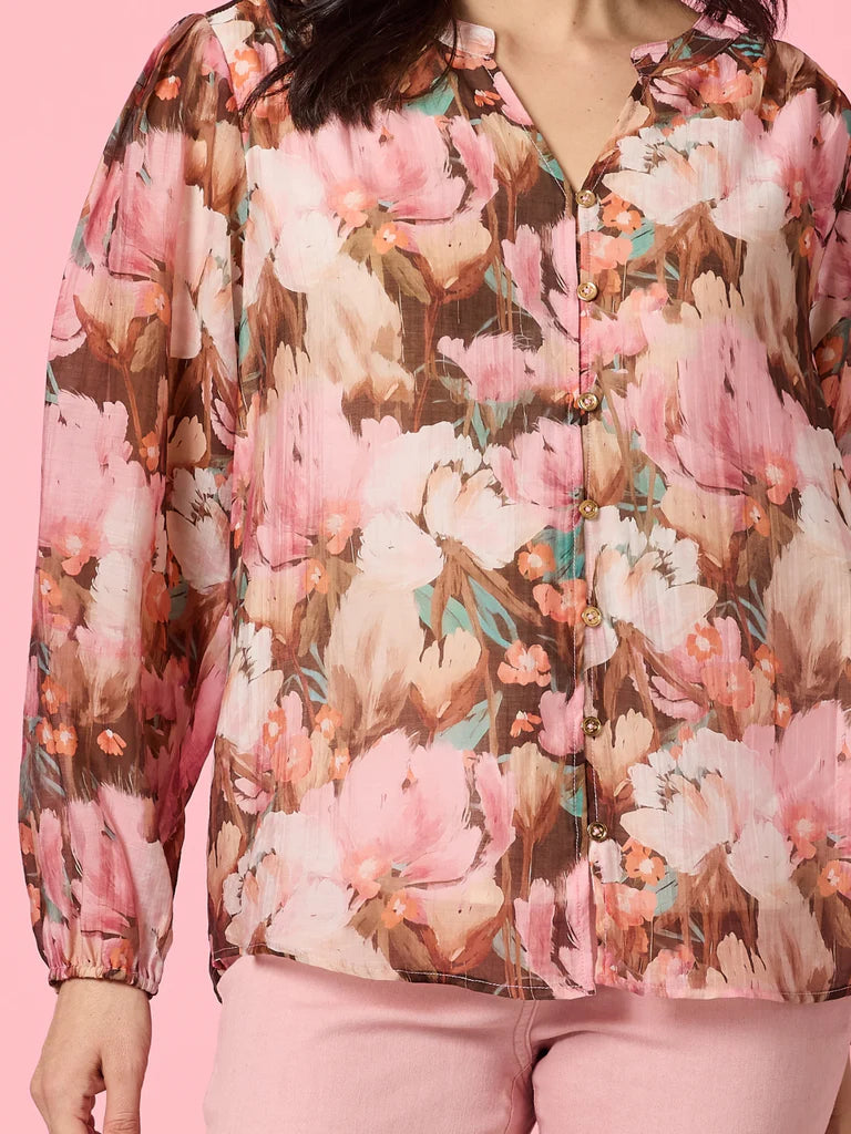 Image of Woman wearing Gordon Smith Floral patterned blouse on a pink background 