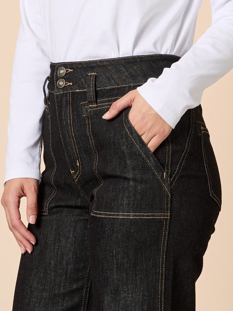 Image of Woman wearing Gordon Smith dark jeans with a beige background