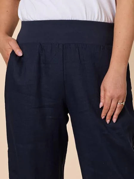 Gordon Smith navy pants worn by a woman on a beige background