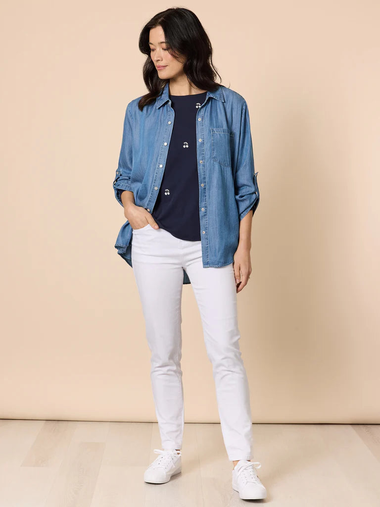 Image of Woman wearing a Gordon Smith denim shirt with white jeans on a beige background