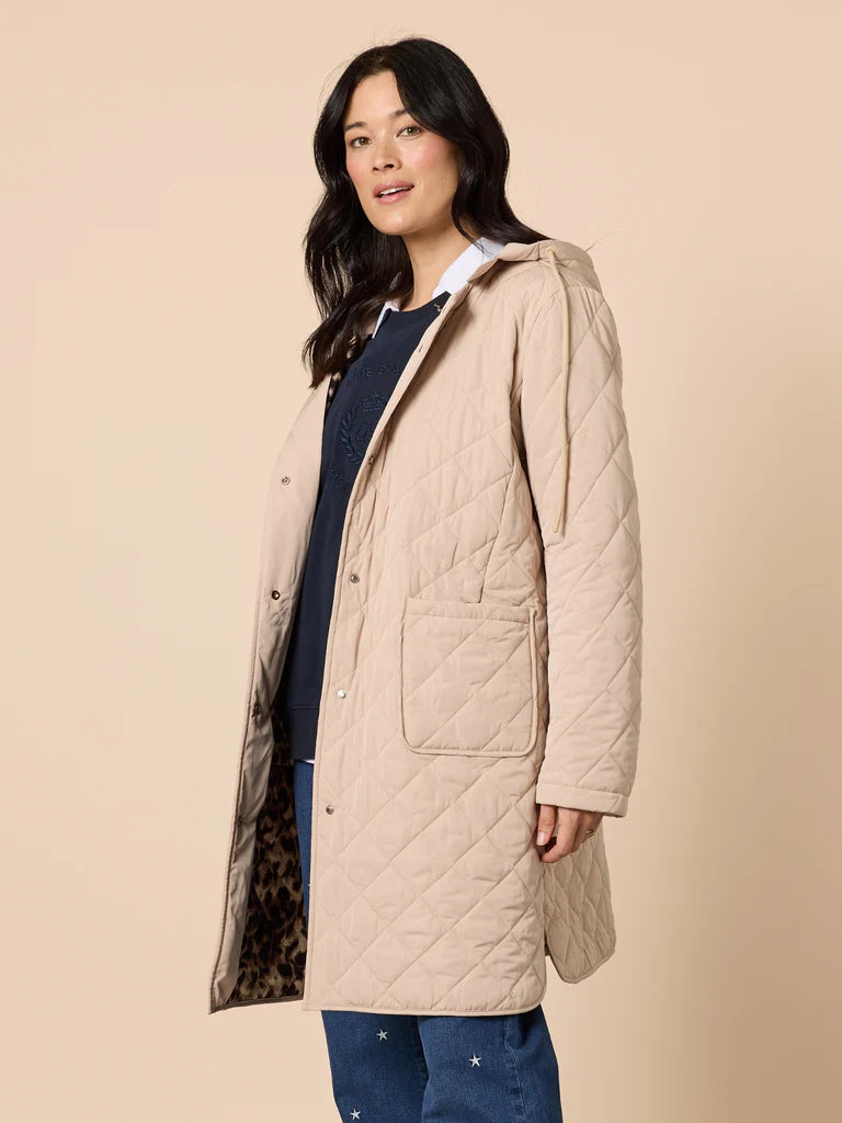Woman wearing a Gordon Smith beige quilted coat on a beige background
