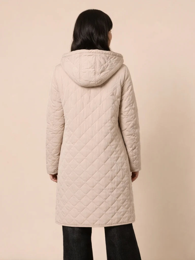 Woman wearing a Gordon Smith beige quilted coat on a beige background