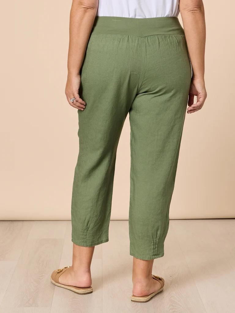 Women wearing Gordon Smith green pants on a beige background