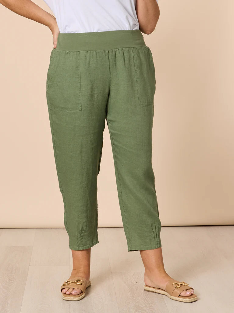Women wearing Gordon Smith green pants and a white top on a beige background