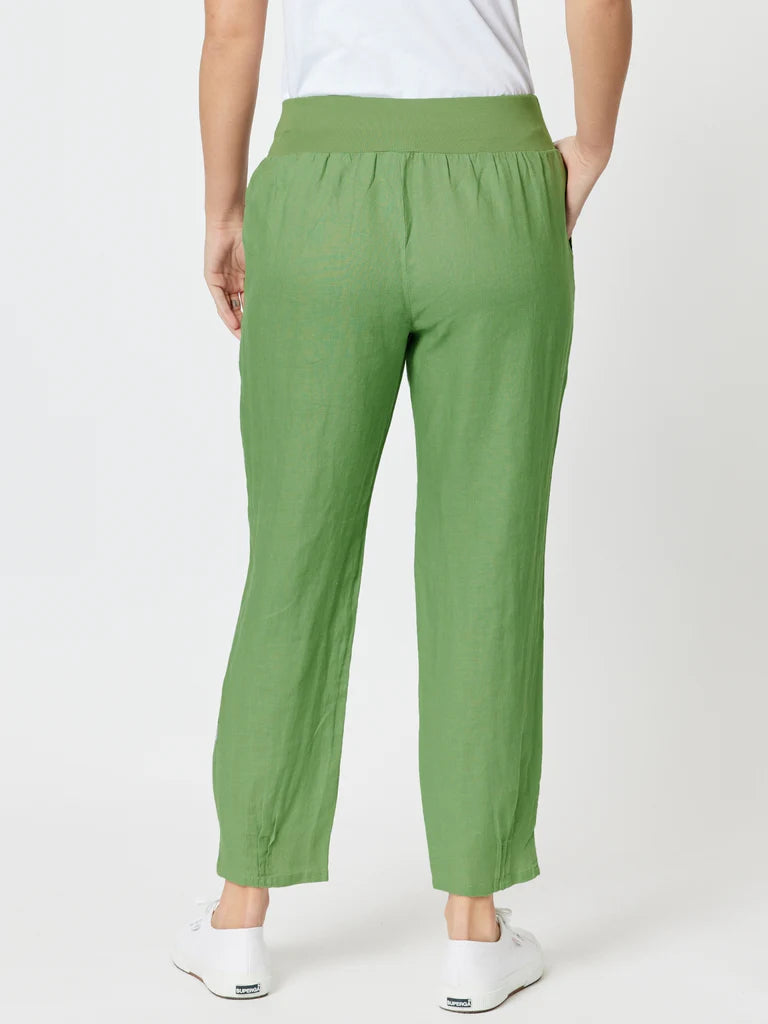 Image of A woman shown from the back wearing Gordon Smith green cropped pants with an elastic waistband and white sneakers against a light gray studio background.