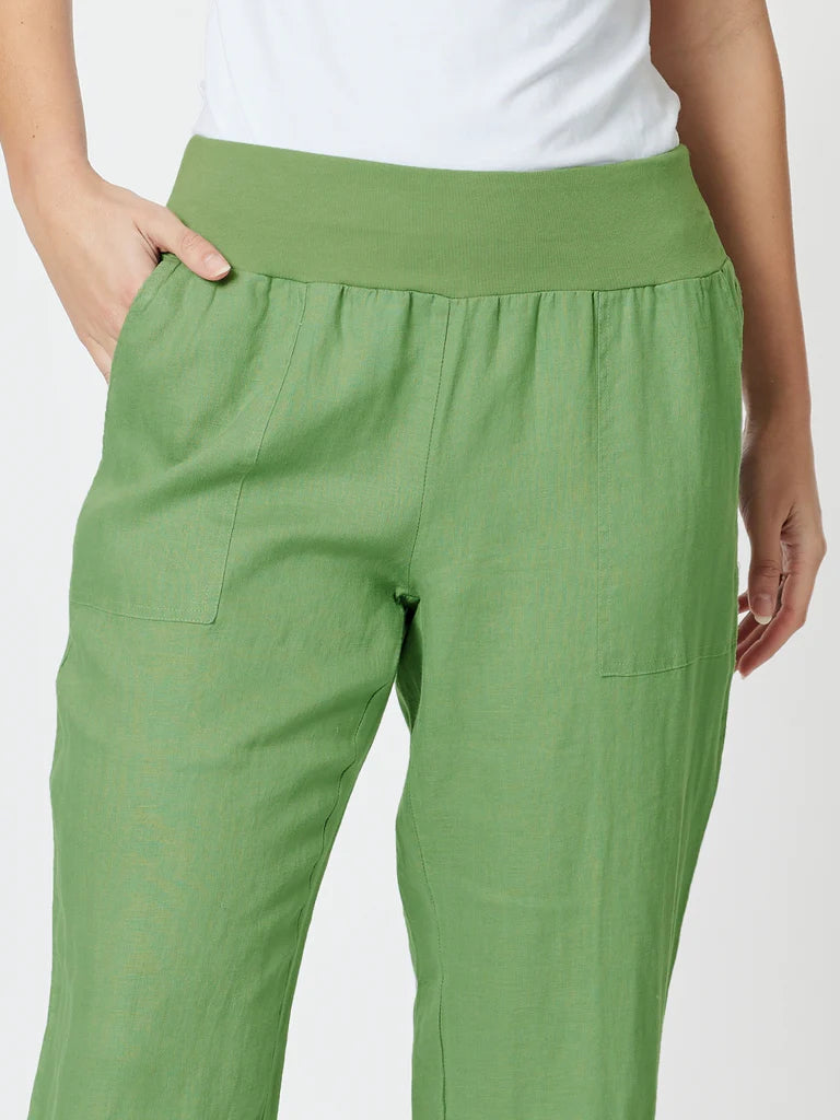 Image of A close-up of a woman wearing Gordon Smith green wide-leg pants with a wide elastic waistband, side pockets, and a white top partially visible at the top edge.