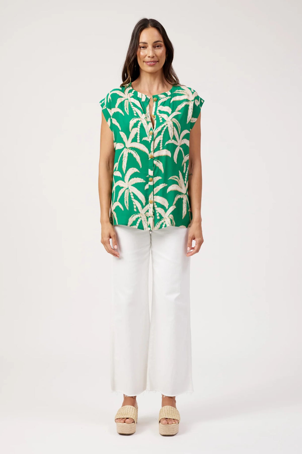 Haven printed top, green palm tree print paired with white denim pants on a plain background 