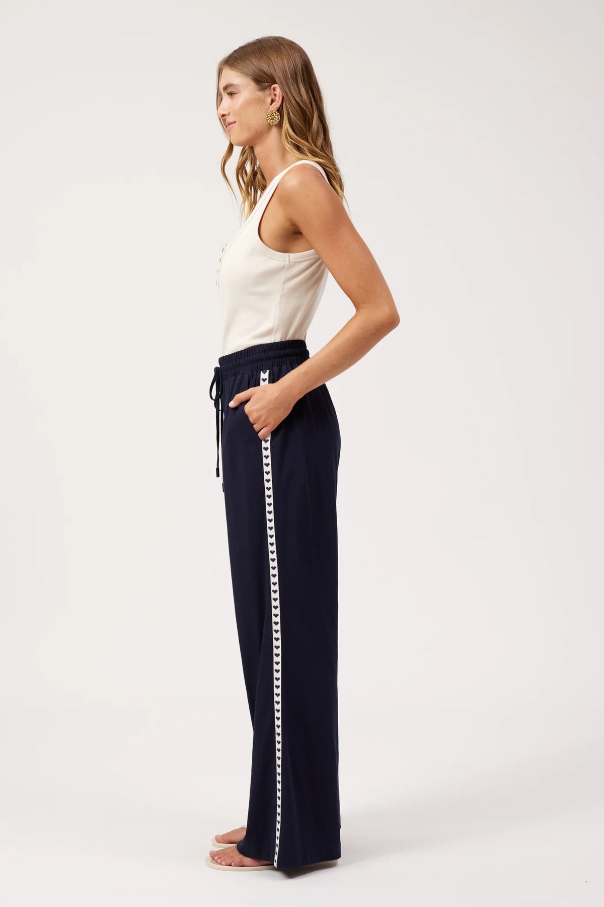 A woman shown from the back wearing Haven navy wide-leg pants with a white sleeveless top, standing against a plain white studio background.
