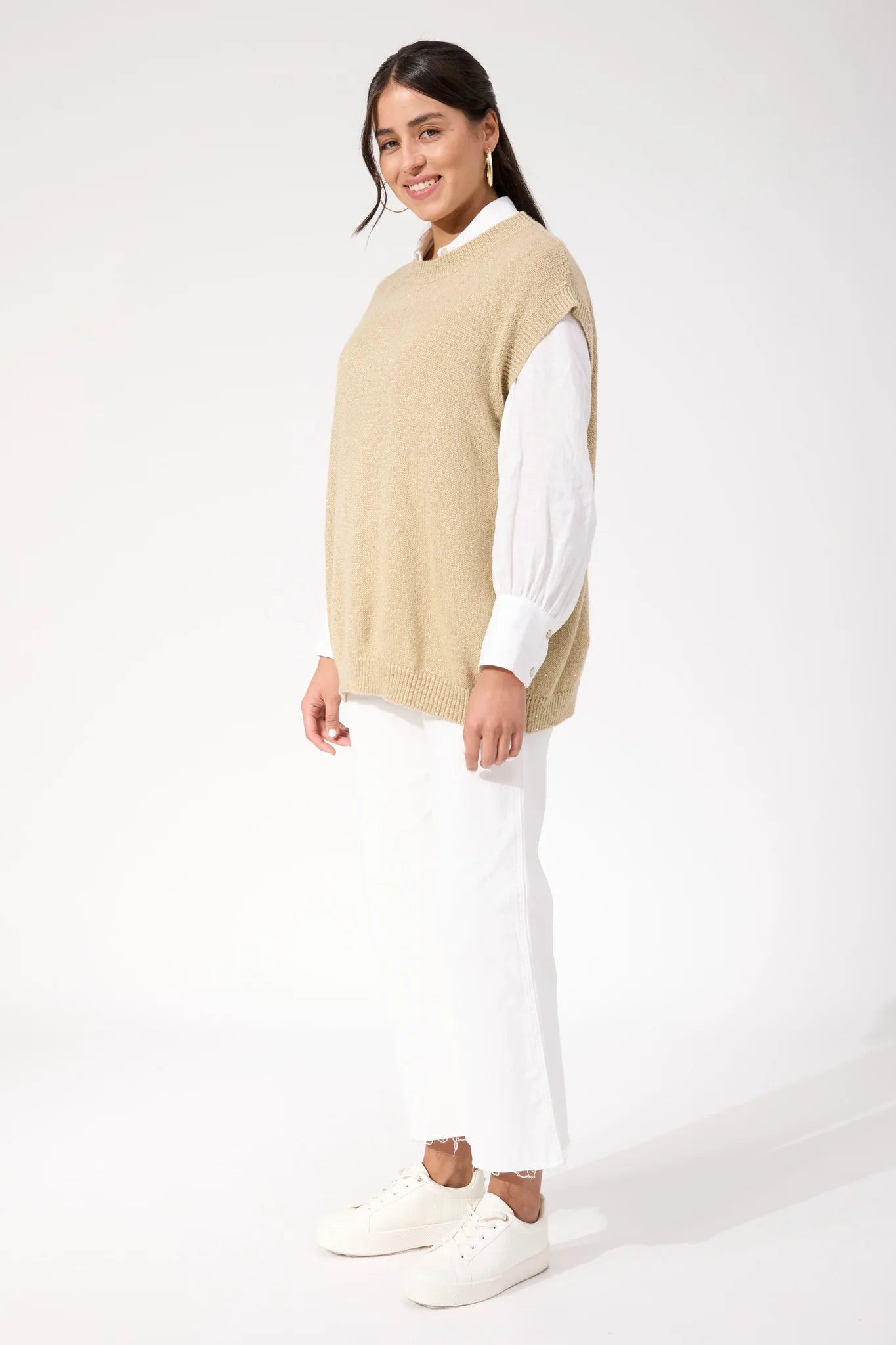 Woman wearing Haven sparkle vest paired with white jeans on a plain background