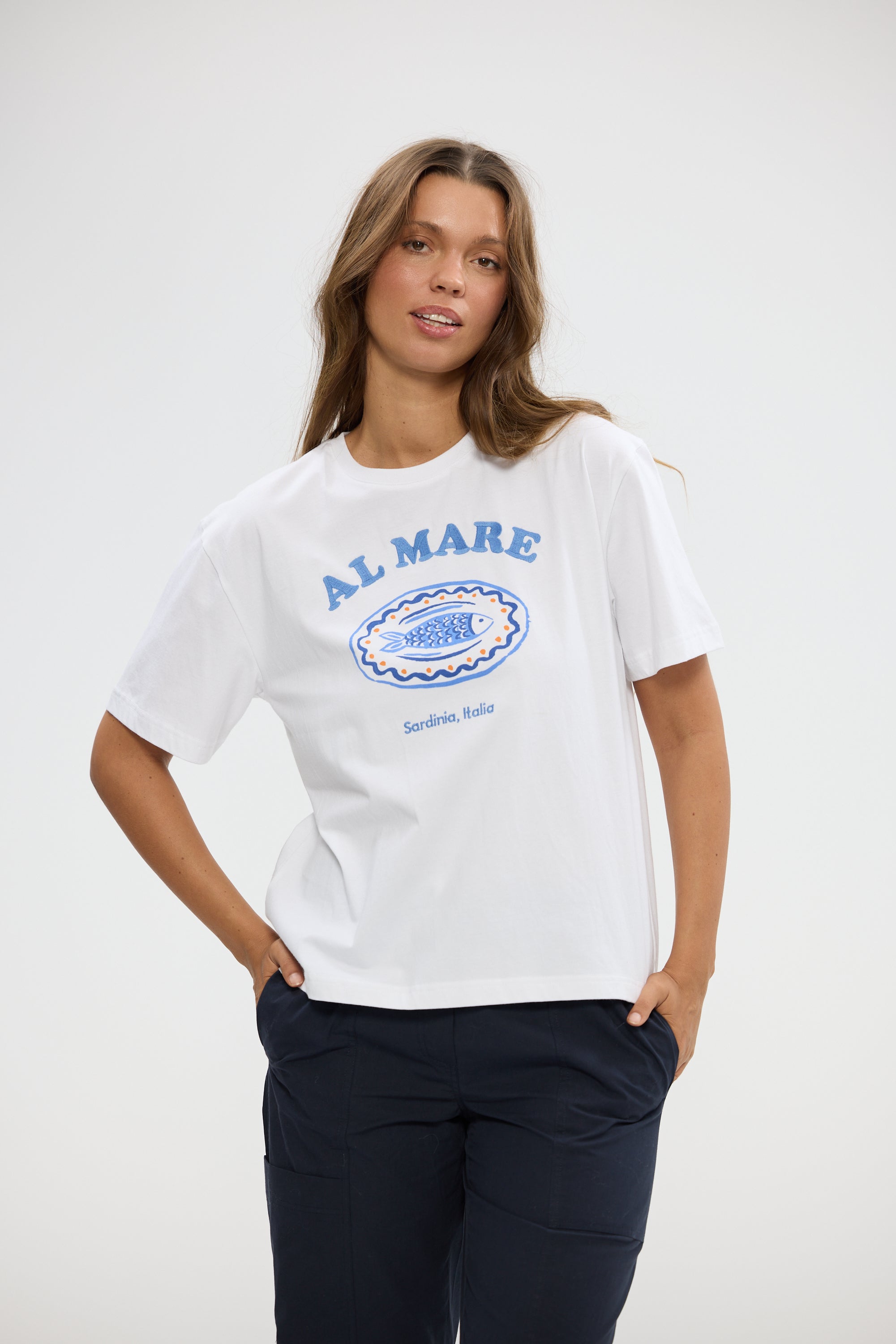 Image of Woman wearing a Holiday white t-shirt with 'ALMARE' branding on a plain background