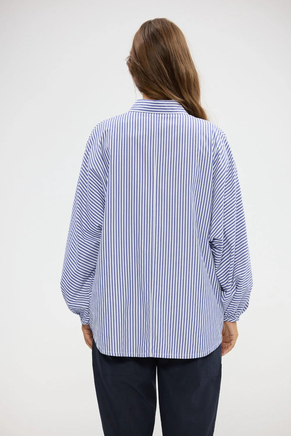 Image of Woman wearing a Holiday blue and white striped shirt on a plain background