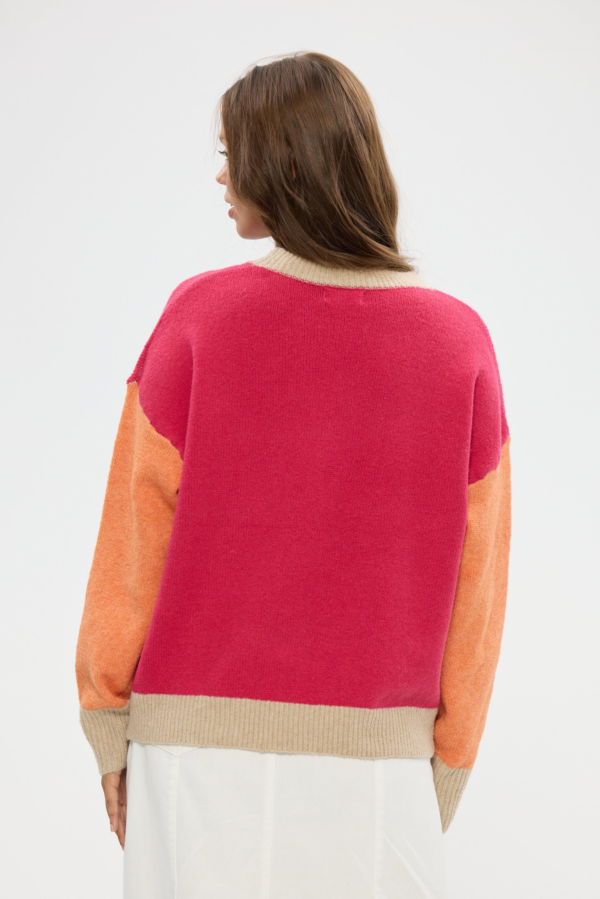Woman wearing a Holiday color-blocked sweater with pink, orange, and beige sections on a white background.