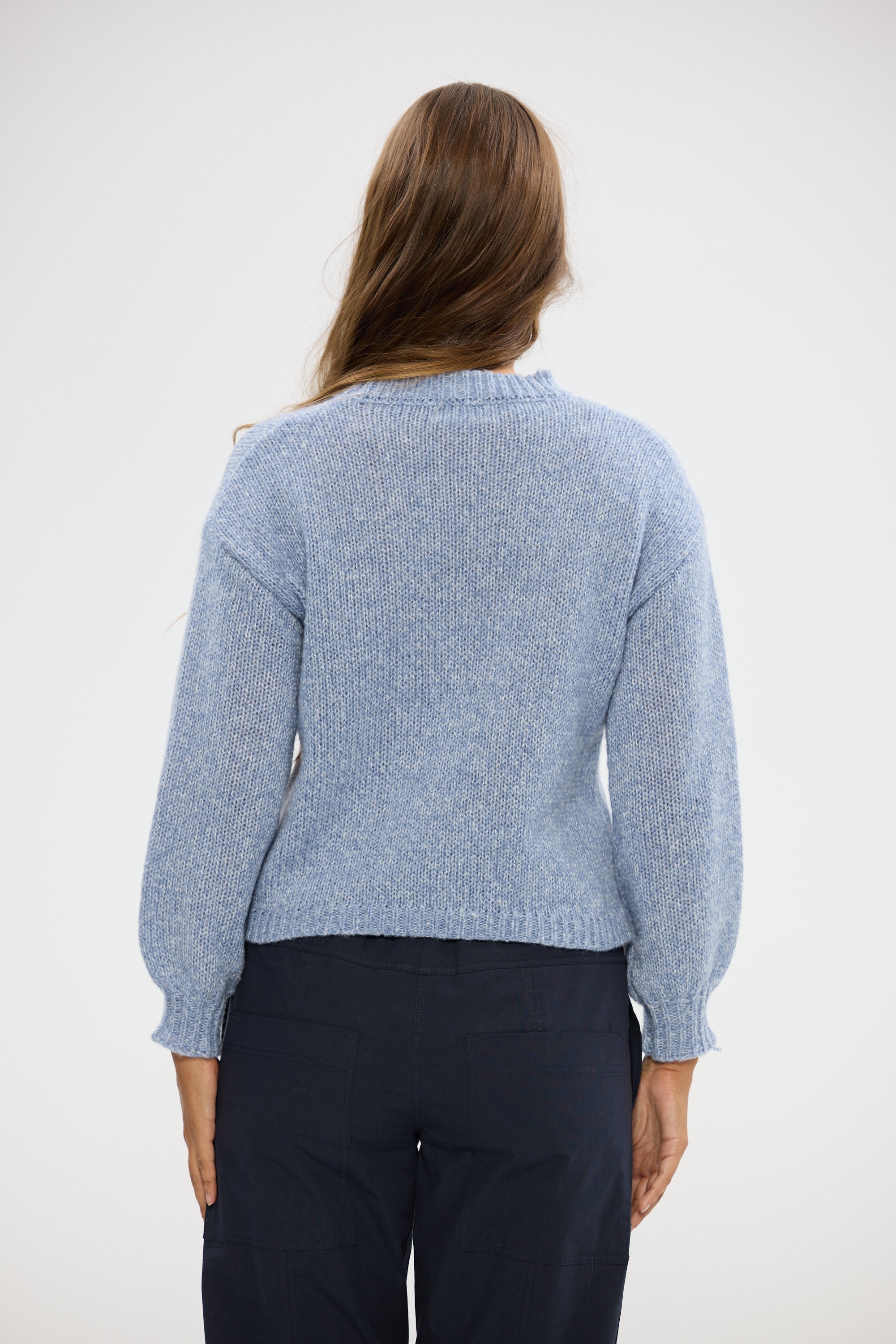 Image of Woman wearing a Holiday light blue sweater against a white background