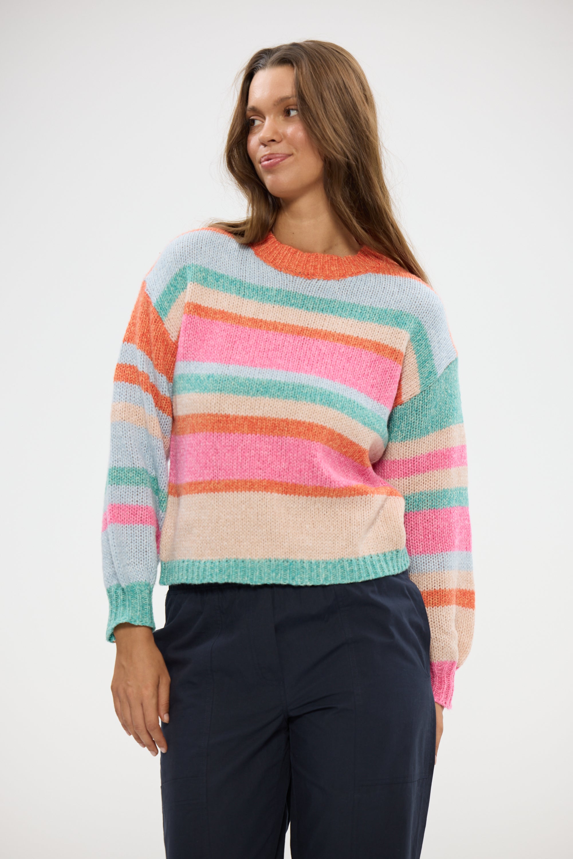 Image of Woman wearing a Holiday colorful striped sweater against a white background