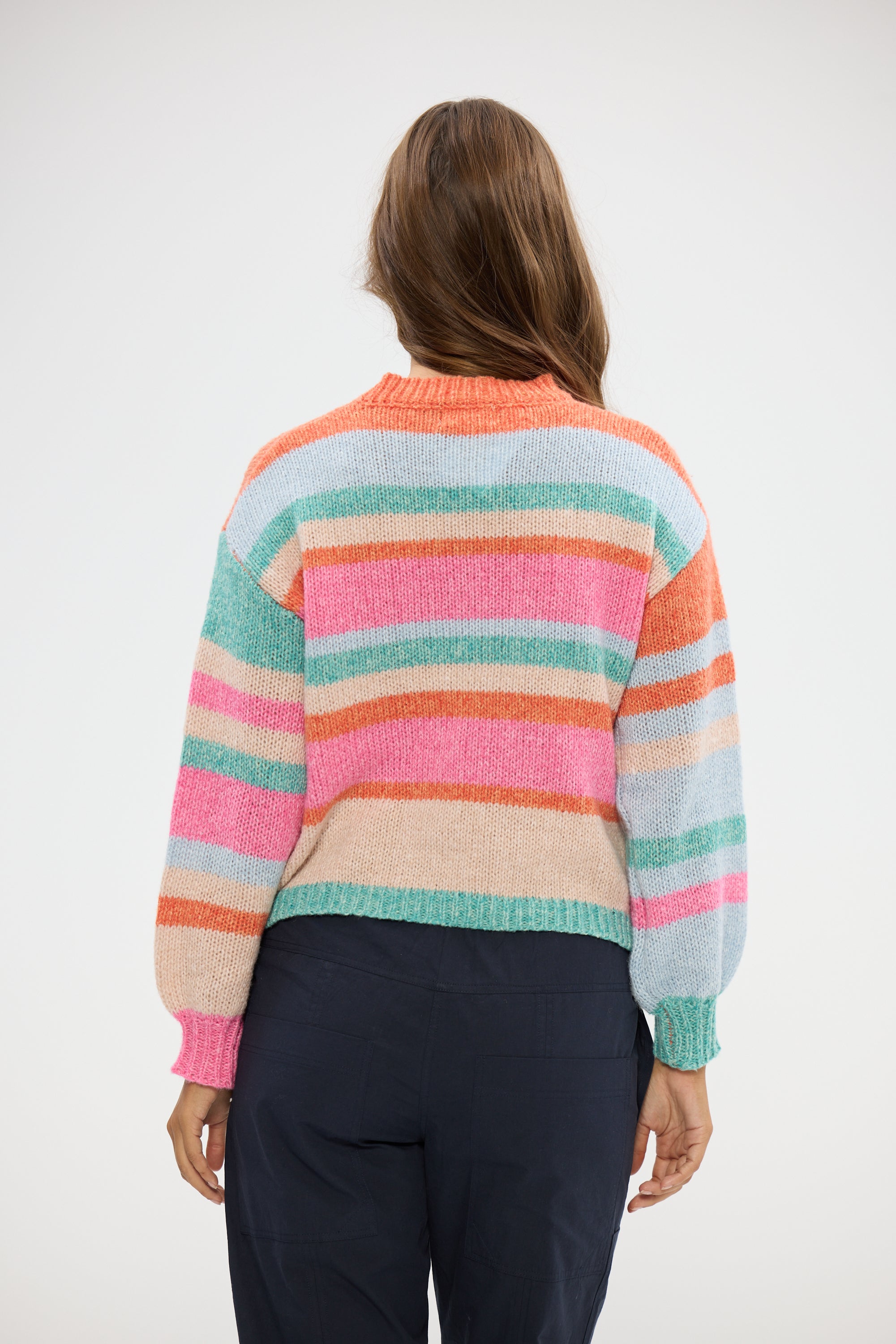 Image of Woman wearing a Holiday colorful striped sweater on a white background