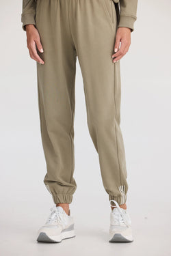 Collection of Person wearing beige jogger pants and white sneakers on a white background in a gallery layout