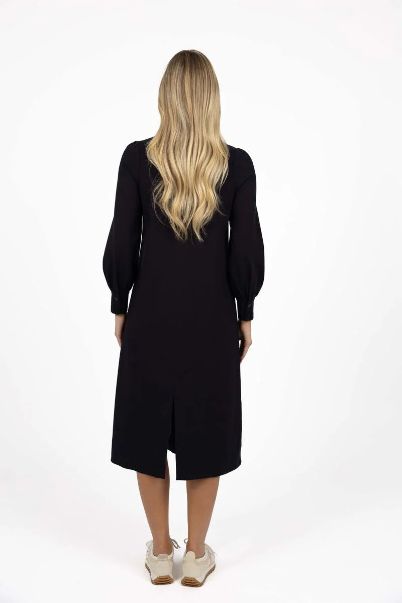 Woman wearing a Humidity black dress with long sleeves on a white background