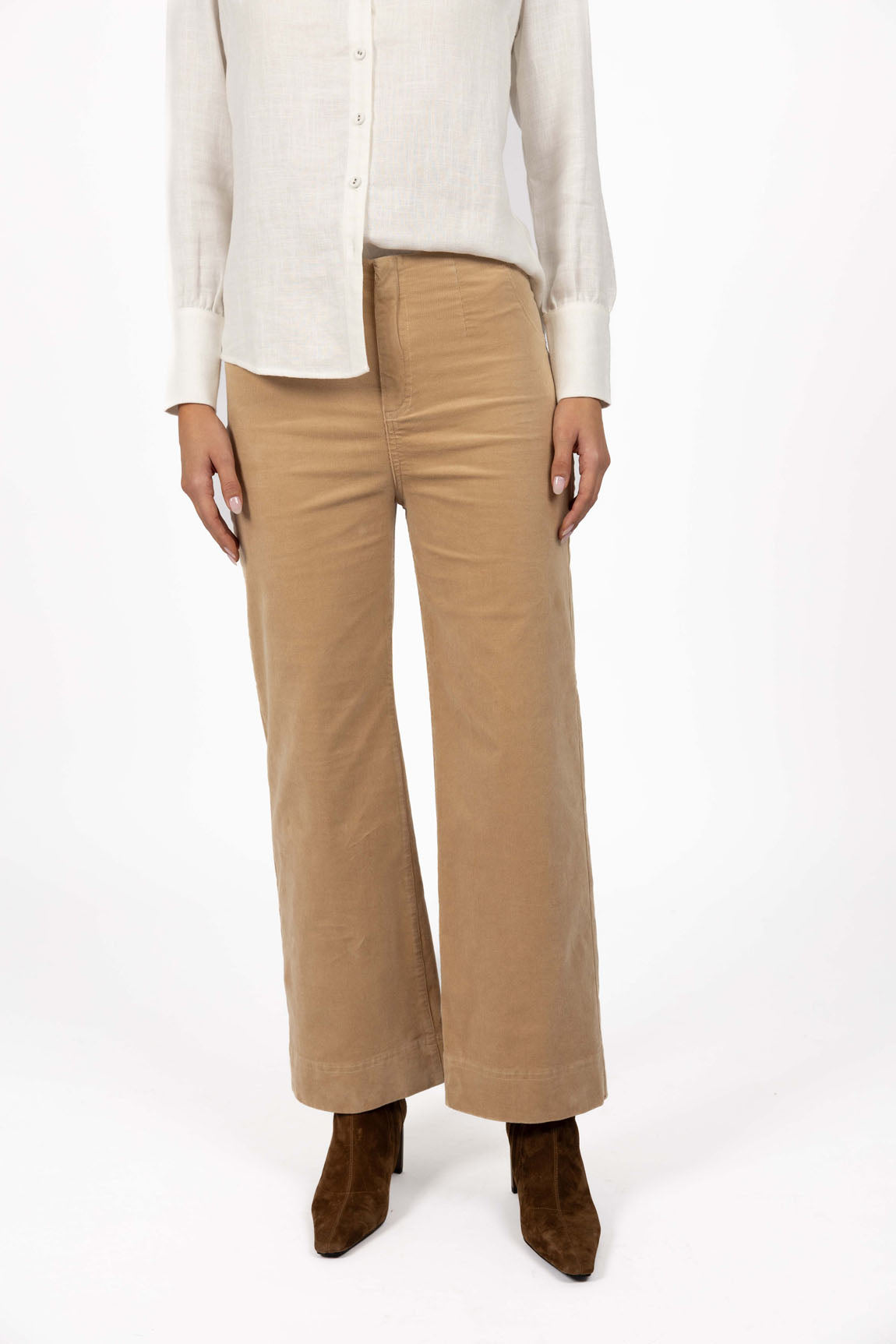Image of Woman wearing a white blouse and Humidity beige pants on a white background