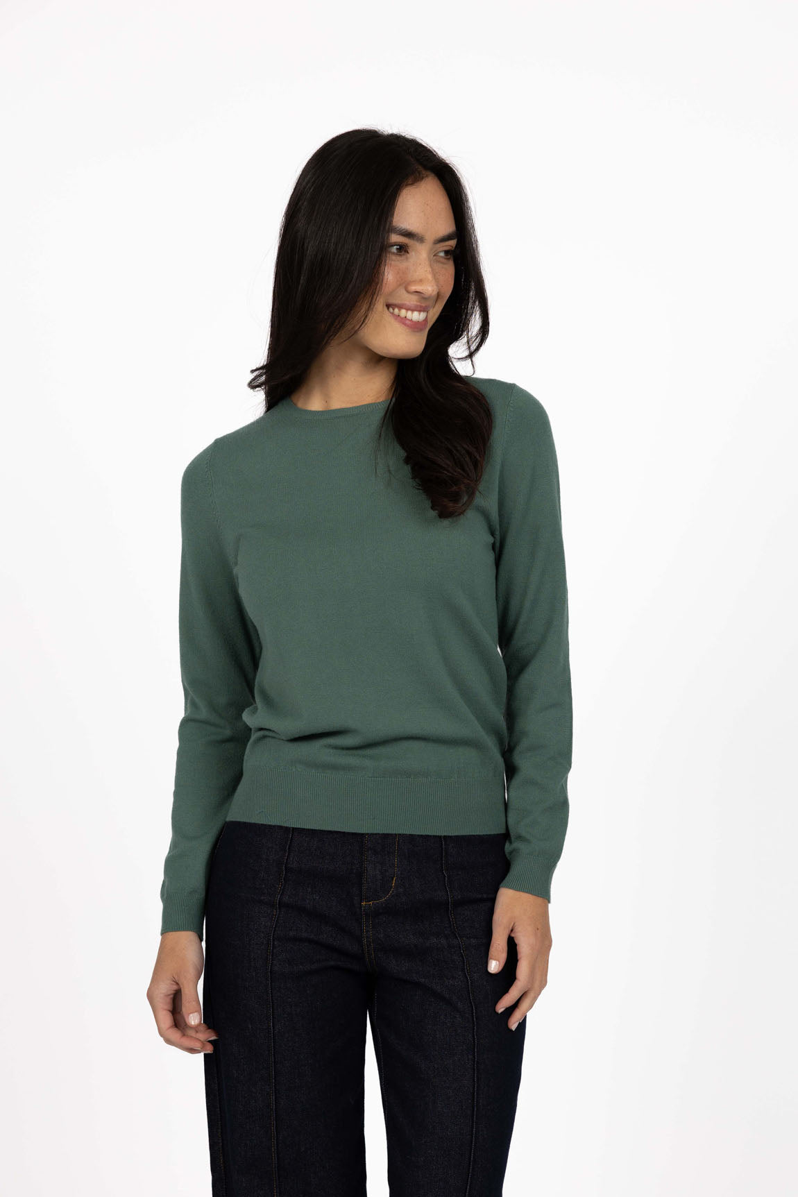 Image of Woman wearing a Humidity green sweater and black pants on a white background