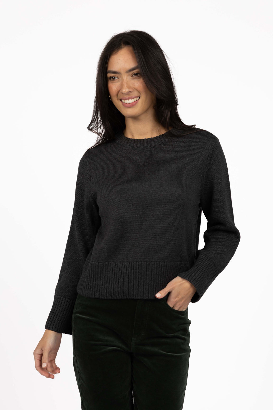 Image of Woman wearing a Humidity black sweater on a white background