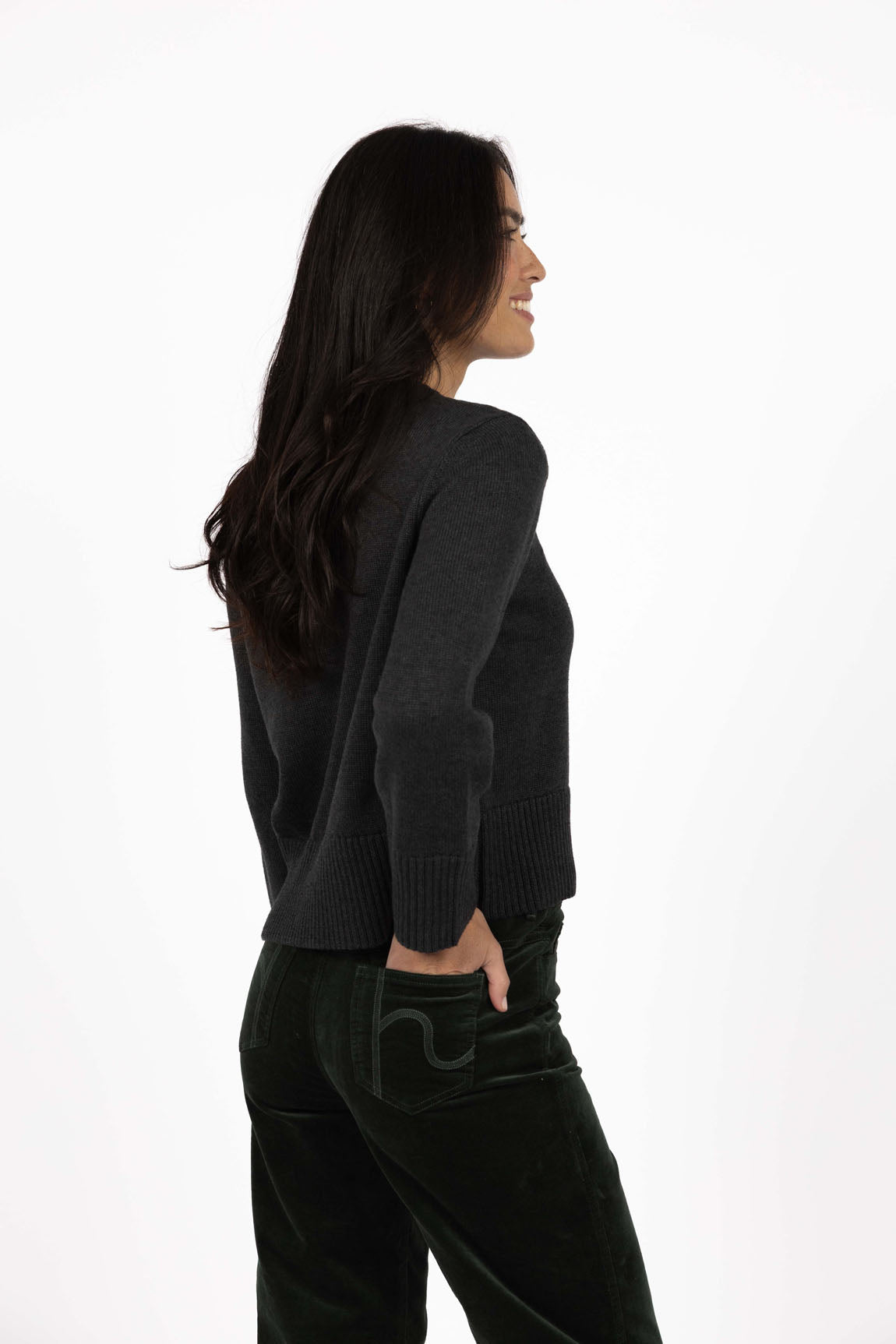 Woman wearing a Humidity black sweater and pants on a white background