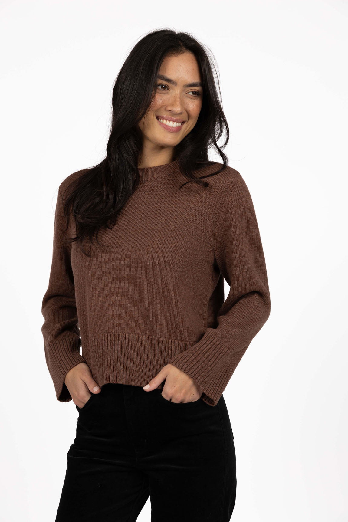 Woman wearing a Humidity Mocha sweater on a white background