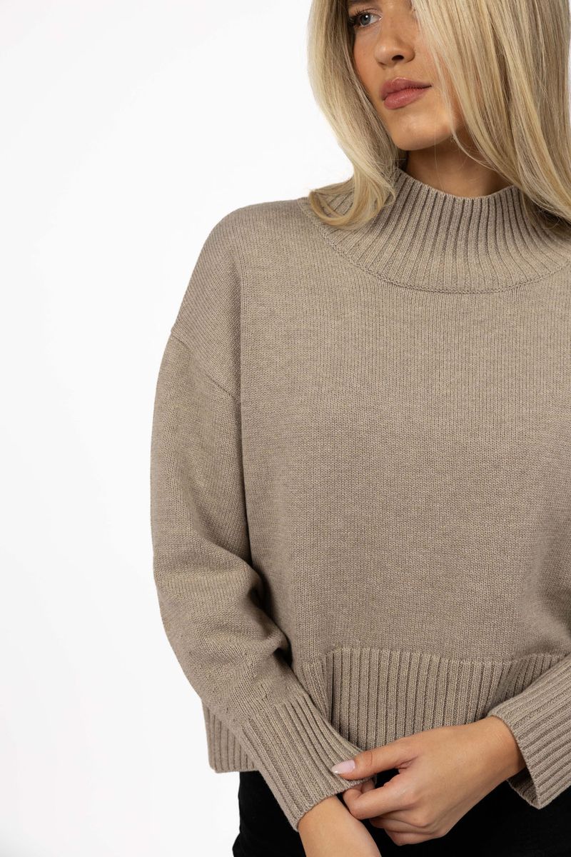 Woman wearing a Humidity beige sweater on a white background