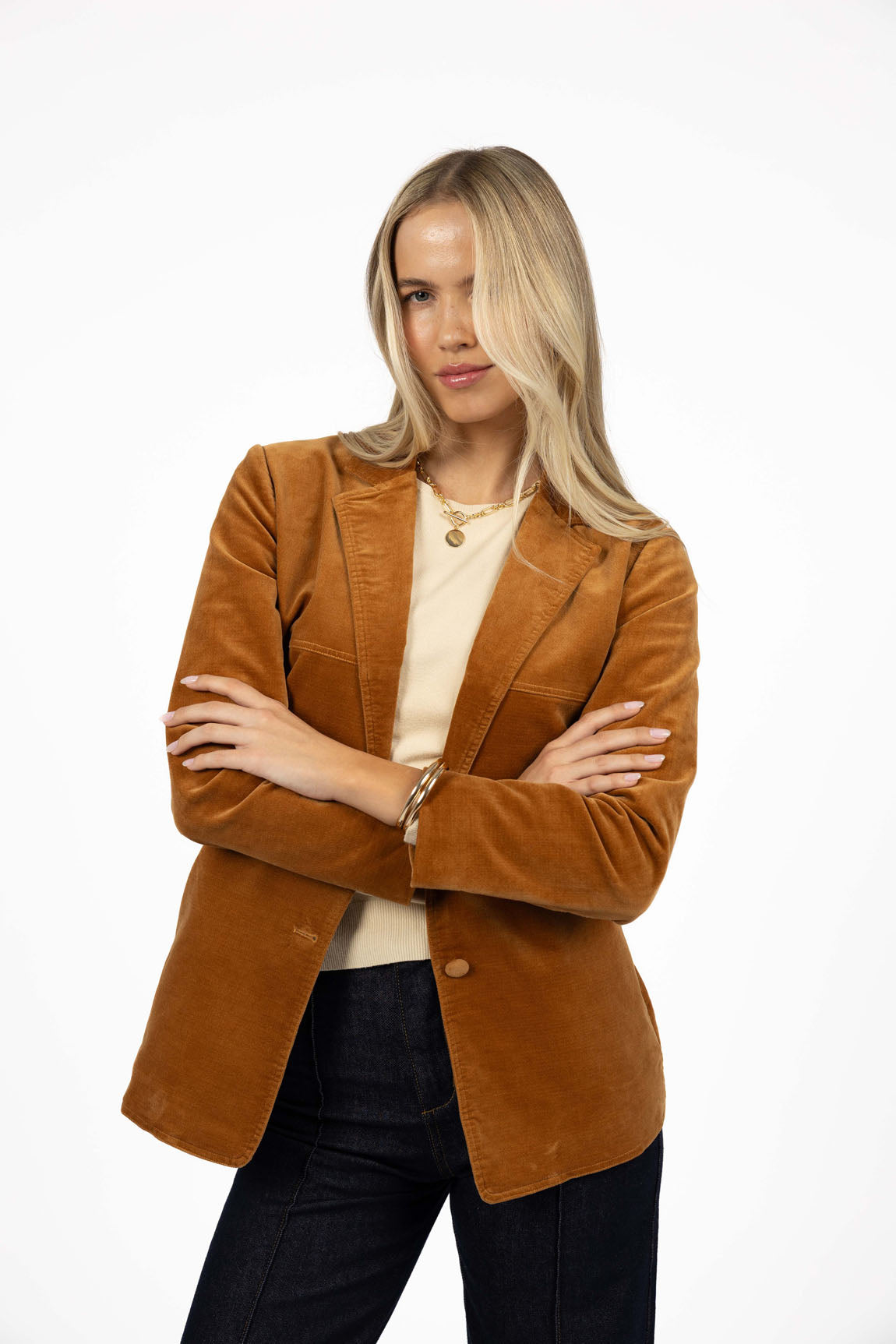 Image of Woman wearing a Humidity Jacket paired with black denim jeans on a white background 