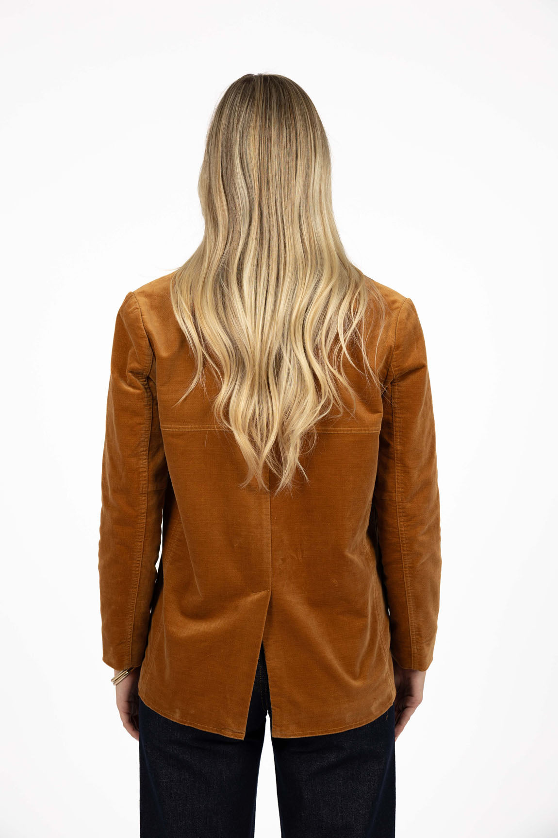 Image of Woman wearing a Humidity Jacket paired with black denim jeans on a white background 