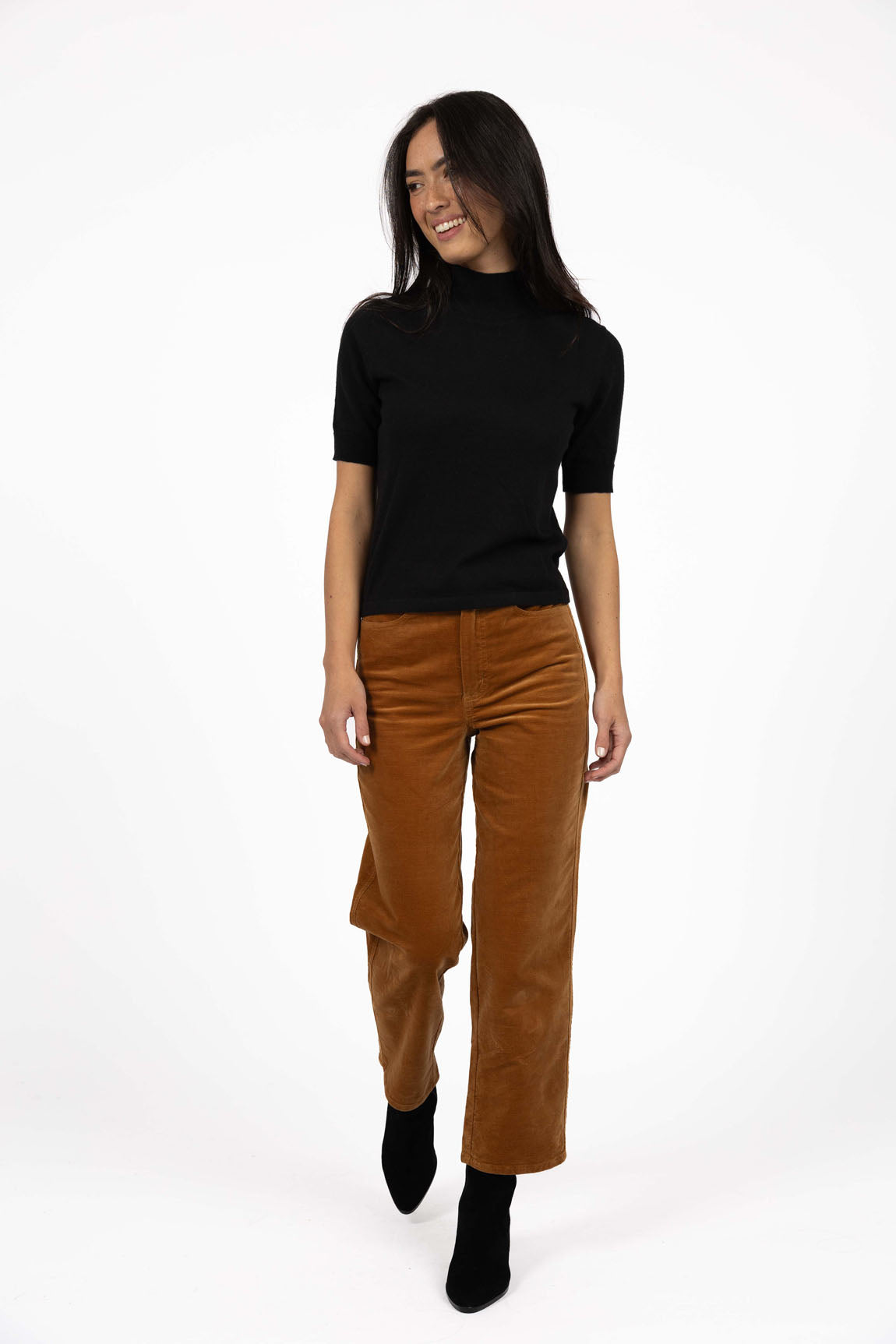 Image of Woman wearing Humidity pants paired with a black top on a white background 