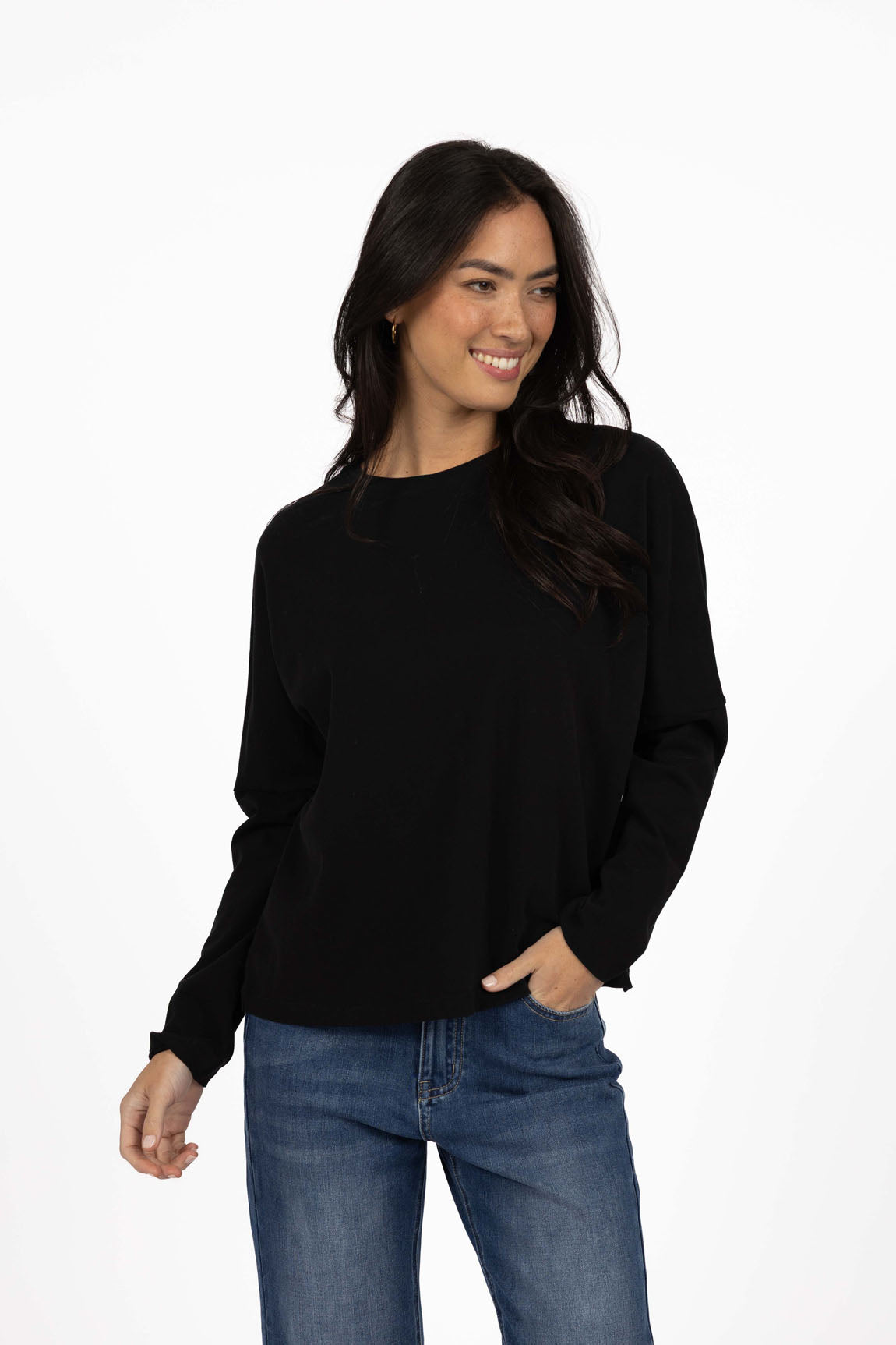Image of Woman wearing a Humidity black long sleeve and blue jeans on a white background