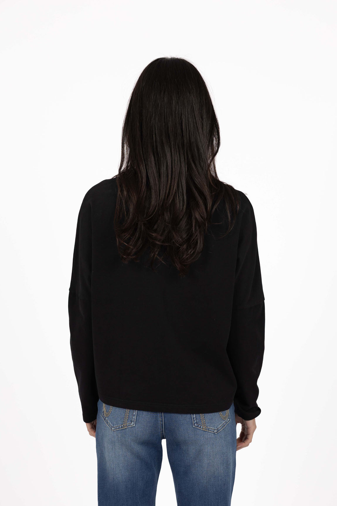 Image of Woman wearing a Humidity black long-sleeve shirt and blue jeans on a white background
