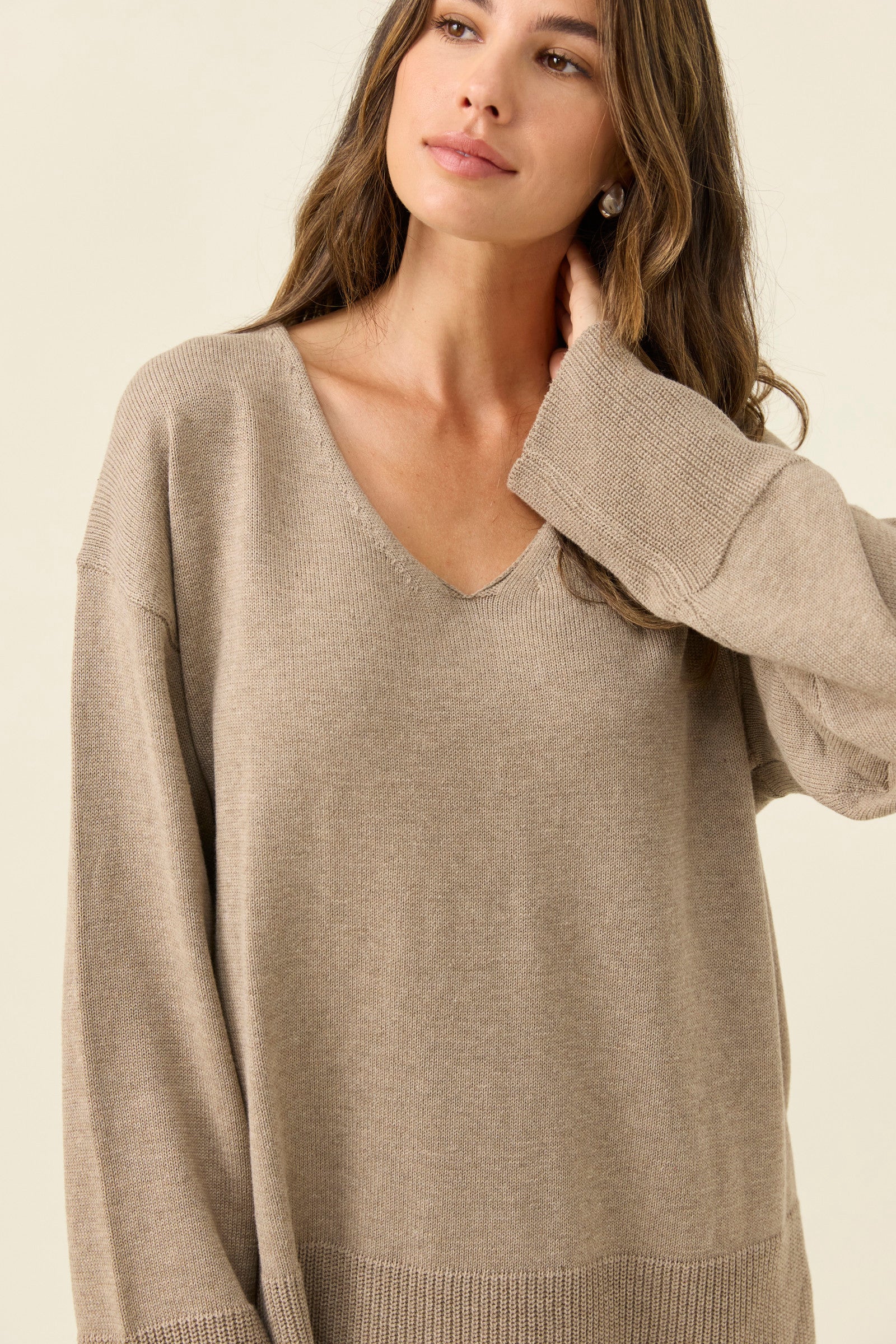 Woman wearing a Isle of Mine beige sweater against a plain background