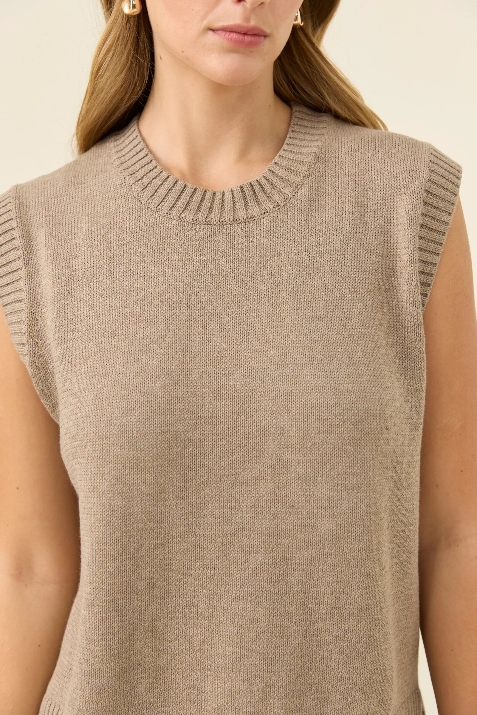 Image of Close-up of a Isle of Mine beige sleeveless knitted top worn by a woman.