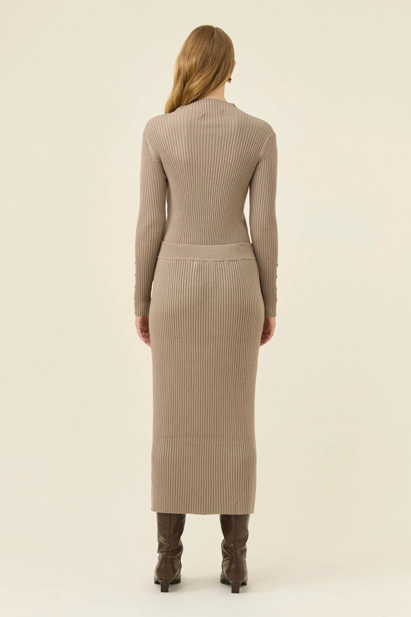 Image of Woman wearing a Isle of Mine beige ribbed skirt and top on a plain background