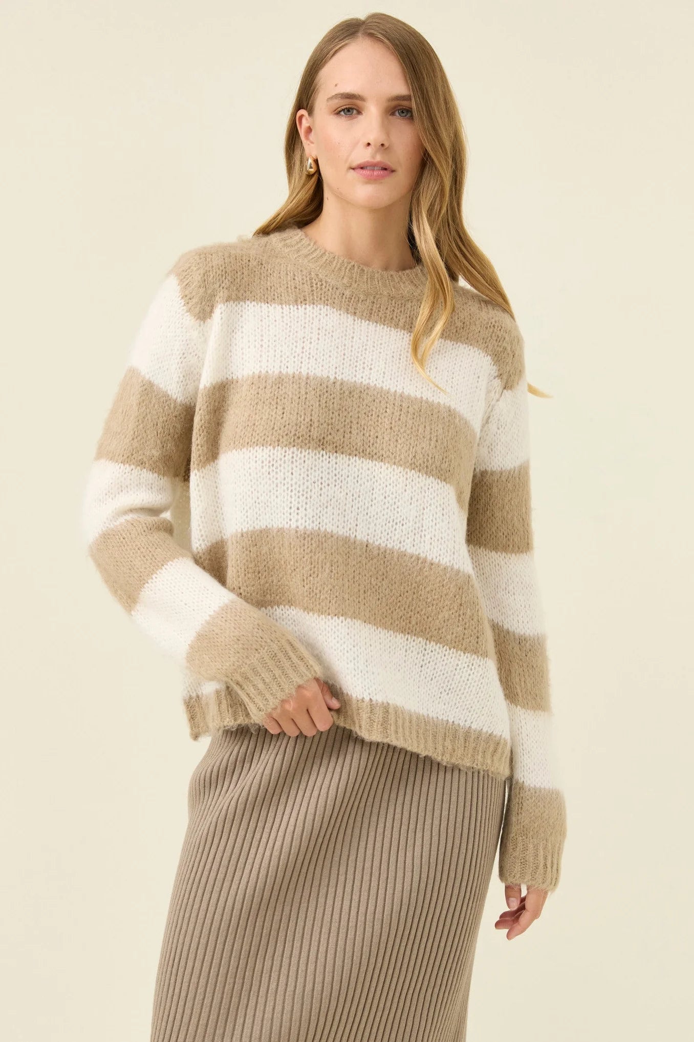 Image of Woman wearing Isle of Mine stripe knit jumper paired with Isle of Mine knit skirt with boots on a plain background
