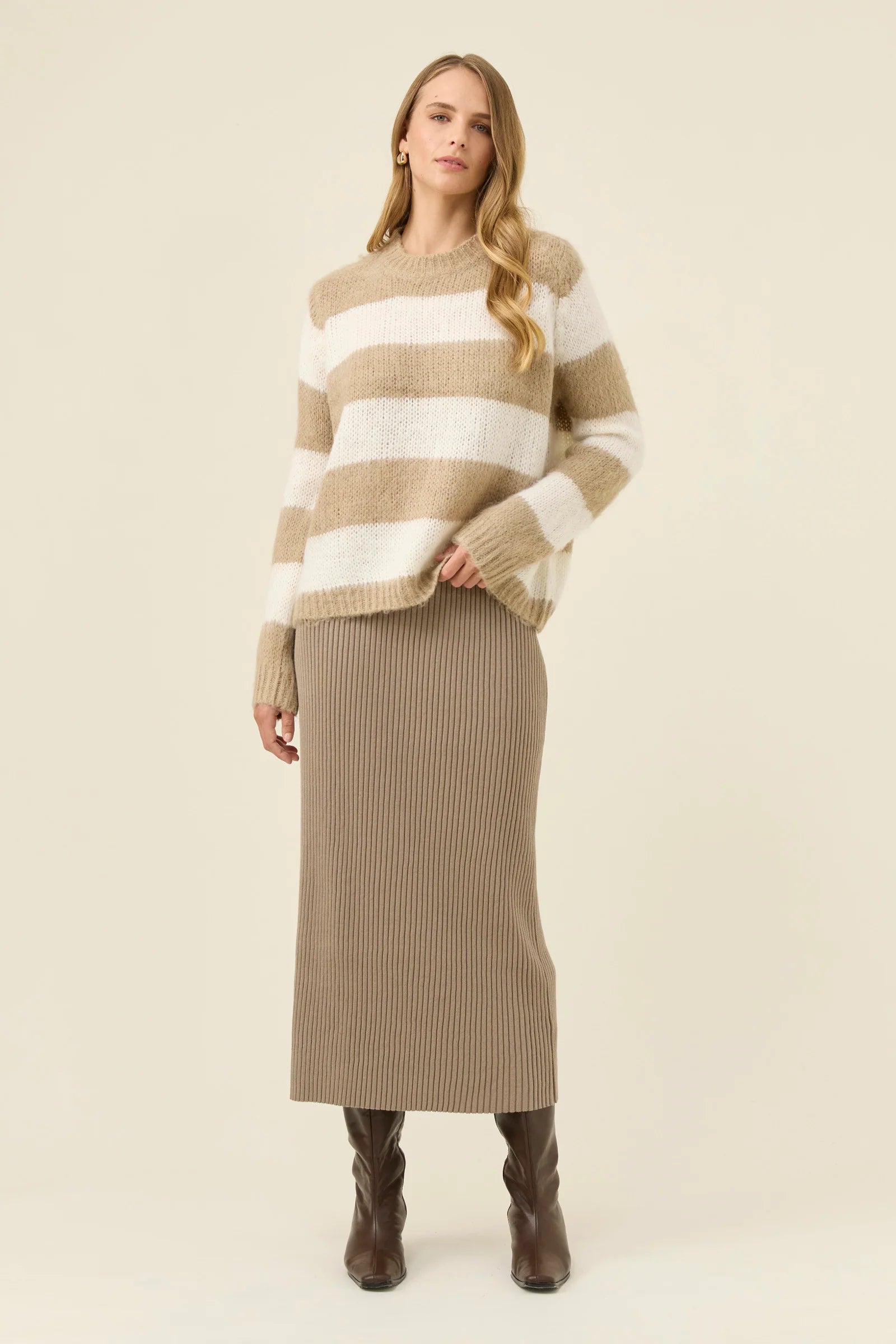Image of Woman wearing Isle of Mine stripe knit jumper paired with Isle of Mine knit skirt with boots on a plain background
