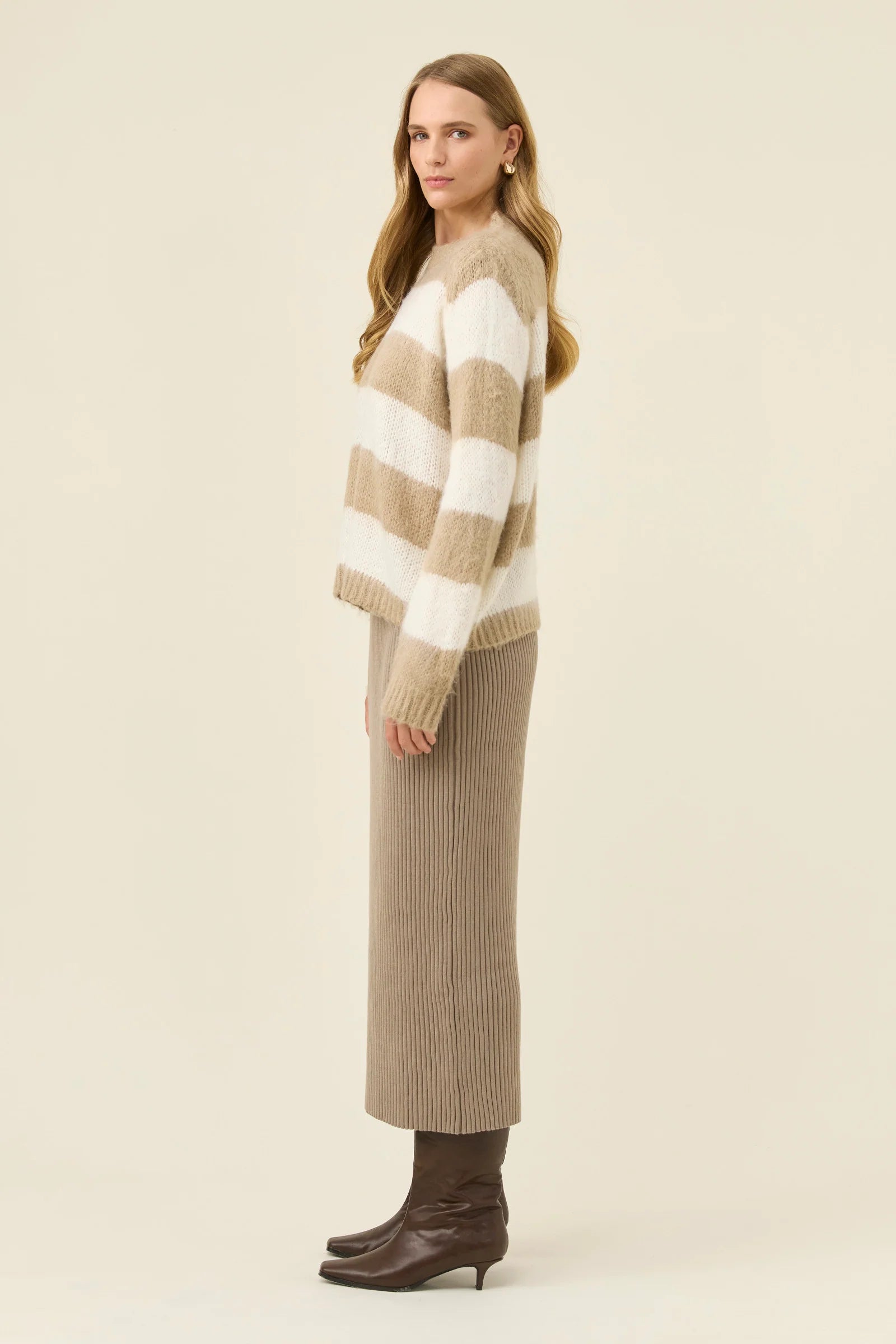 Image of Woman wearing Isle of Mine stripe knit jumper paired with Isle of Mine knit skirt with boots on a plain background