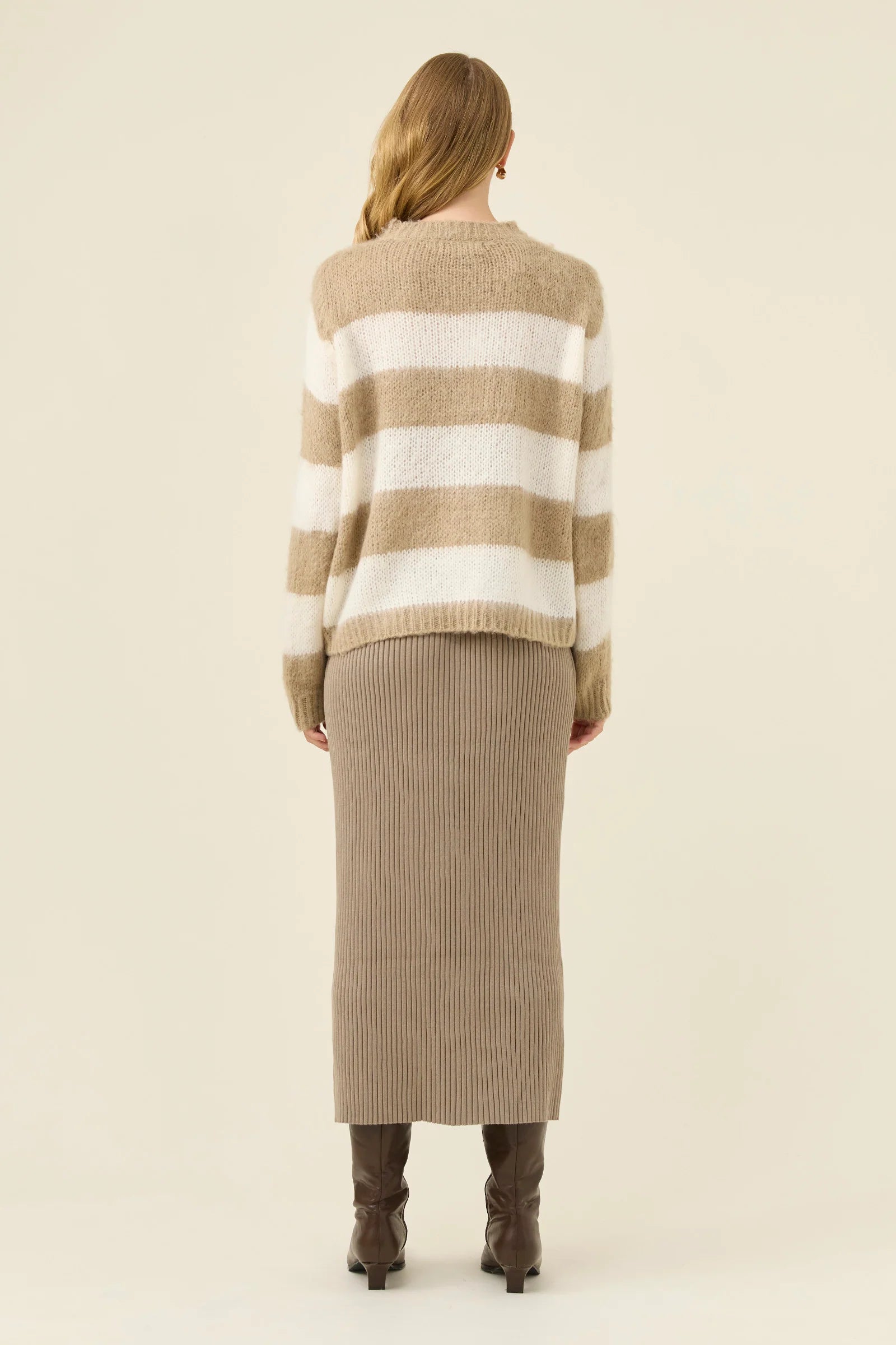 Image of Woman wearing Isle of Mine stripe knit jumper paired with Isle of Mine knit skirt with boots on a plain background