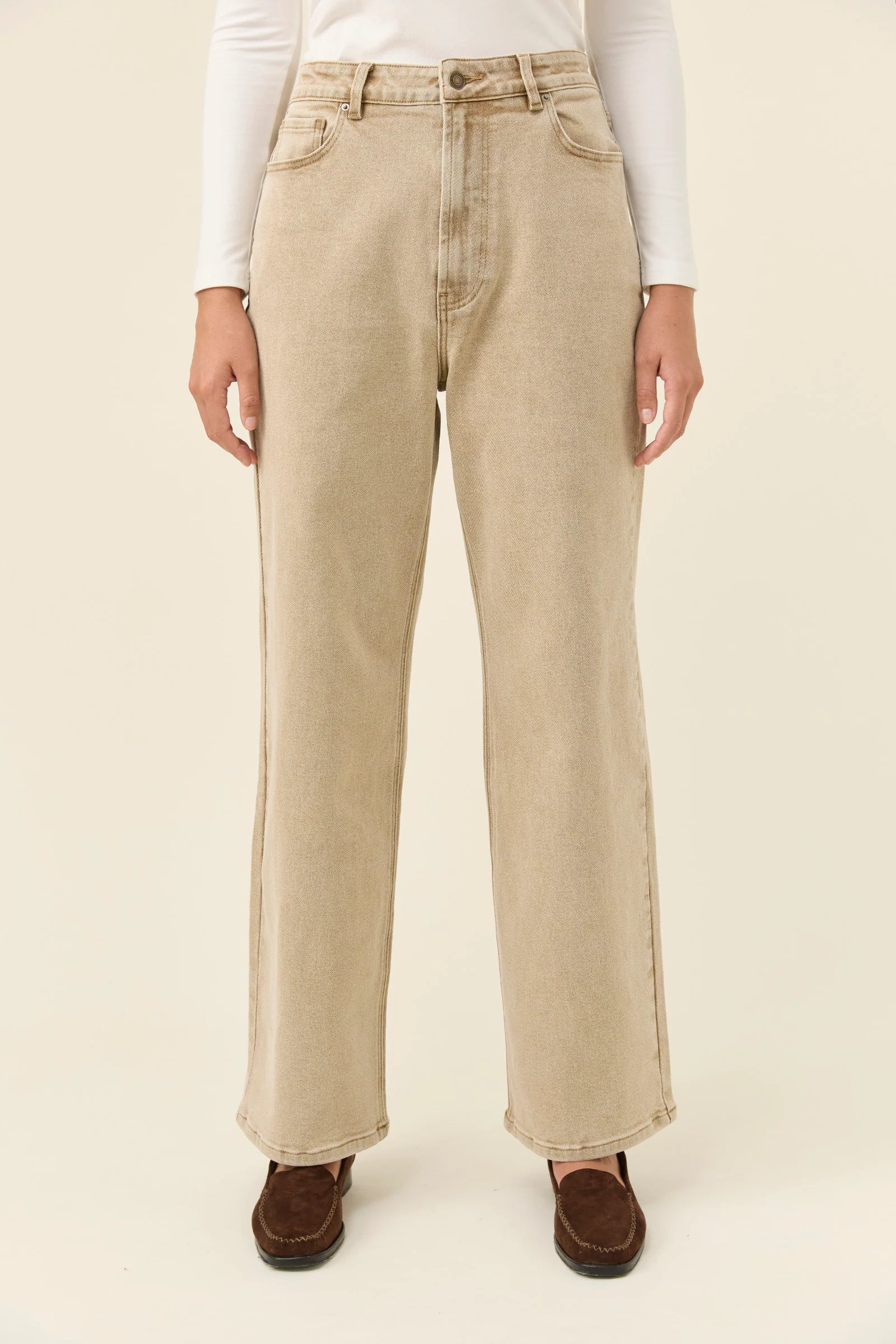 Woman wearing Isle of Mine jeans paired with a white long sleeve on a plain background