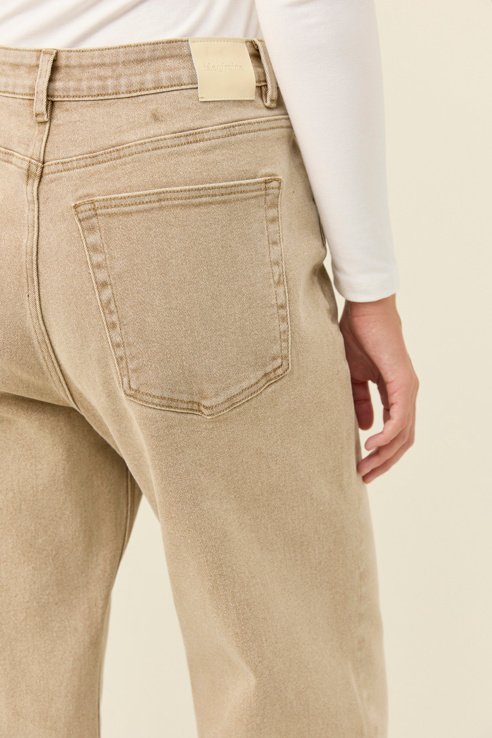 Image of Woman wearing Isle of Mine jeans paired with a white long sleeve on a plain background
