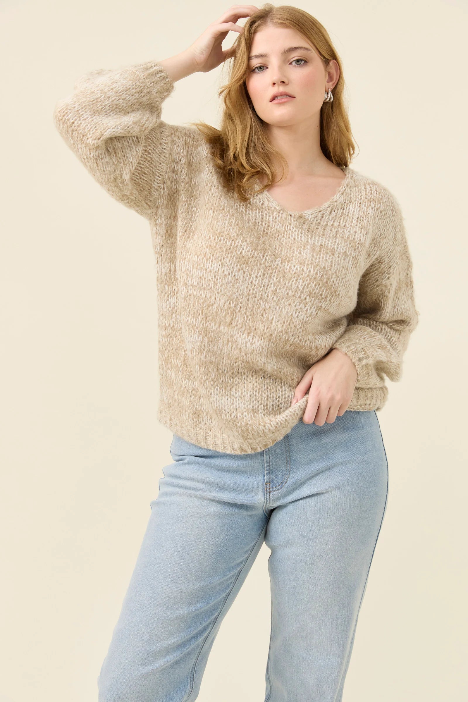 Image of Woman wearing Isle of Mine knit in stone coloured. Paired with denim jeans on a plain background 